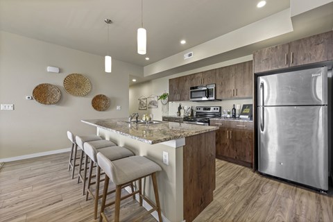 A modern kitchen with a bar area and stainless steel appliances.