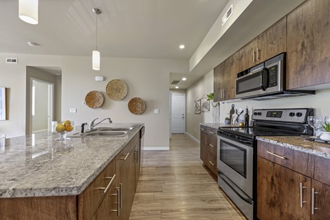 A modern kitchen with wooden cabinets and a granite countertop.