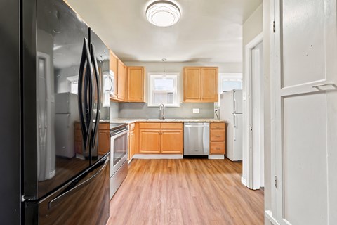 A kitchen with wooden floors and white walls.