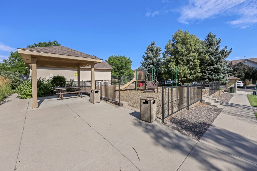 A playground with a swing set and a gazebo.