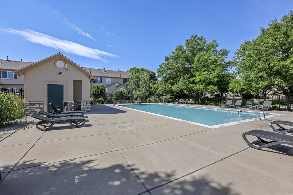 A pool area with a small building and a bicycle.