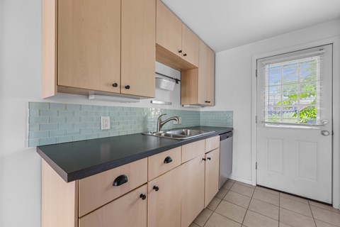 A kitchen with wooden cabinets and a black countertop.