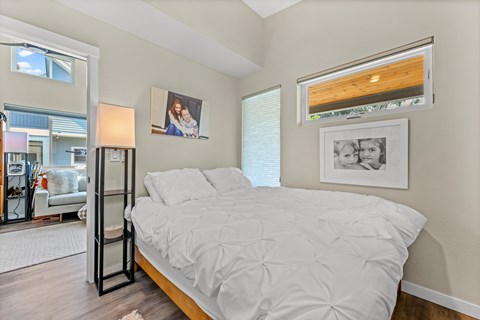 A bedroom with a large bed and a picture of a woman and child on the wall.