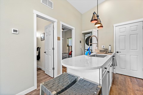 A kitchen with a white countertop and a white sink.