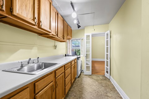 A kitchen with wooden cabinets and a white sink.