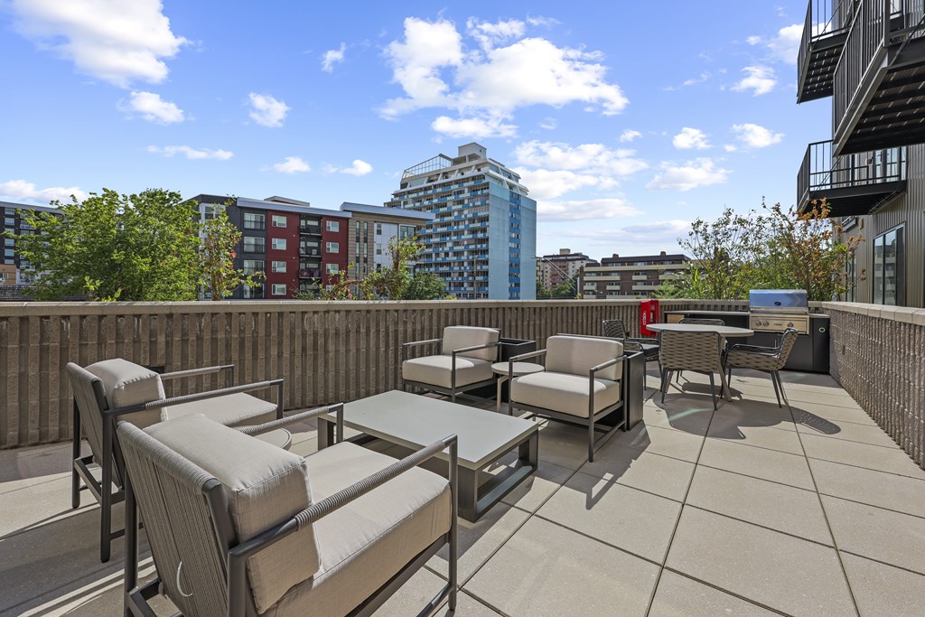 A patio with chairs and a table is set up on a rooftop.