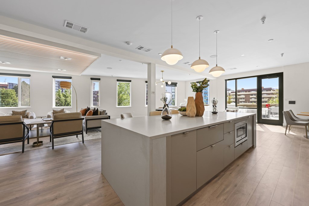 A modern kitchen with a large island and pendant lights.