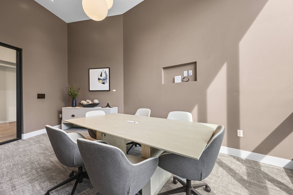 A conference room with a long table and chairs.