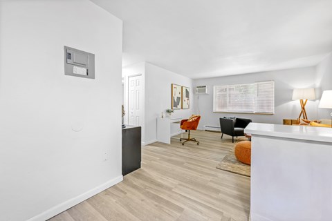A room with a white wall and a wooden floor.