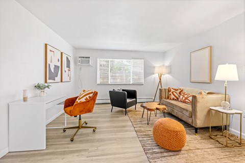 A living room with a white couch, a black chair, and a white side table.