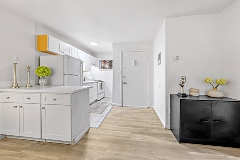 A kitchen with white cabinets and a black dresser.