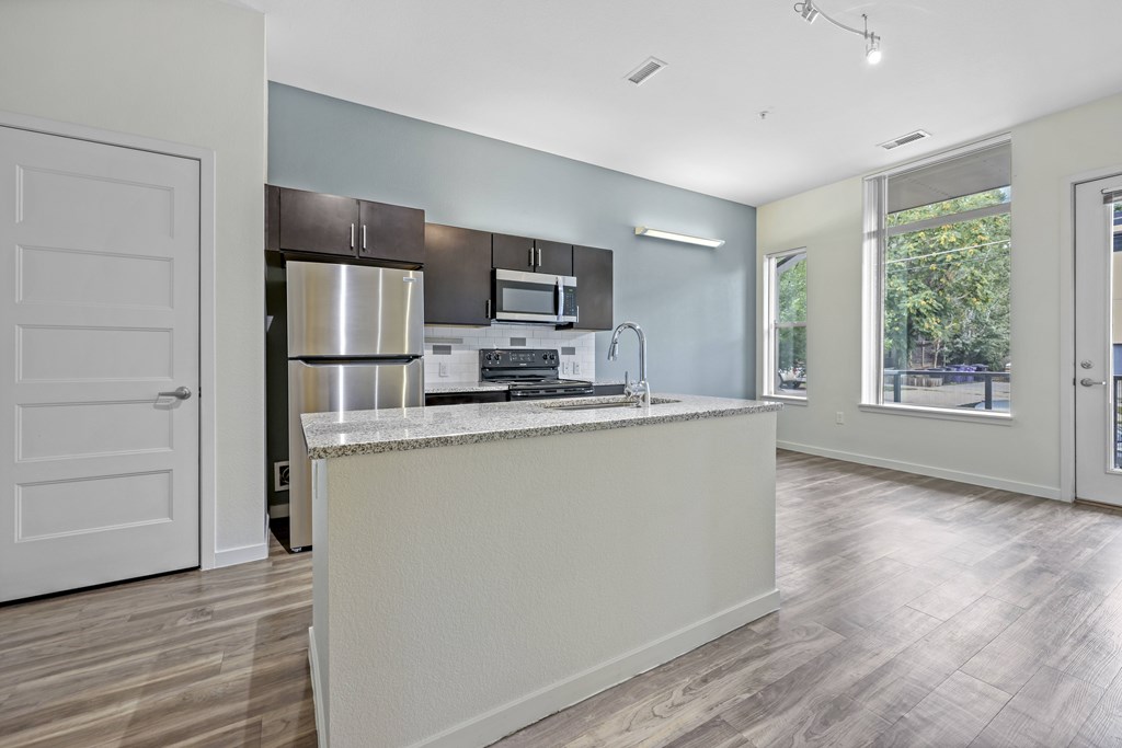A kitchen with a white countertop and stainless steel appliances. at B Street Lohi Apartments, Colorado