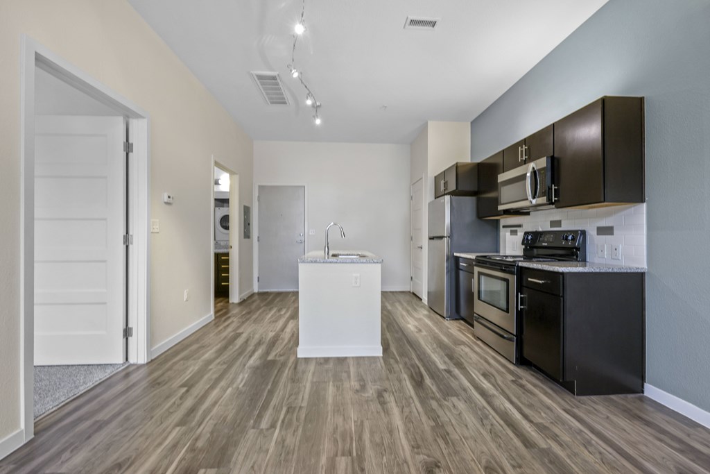 A kitchen with black appliances and brown cabinets. at B Street Lohi Apartments, Denver, CO