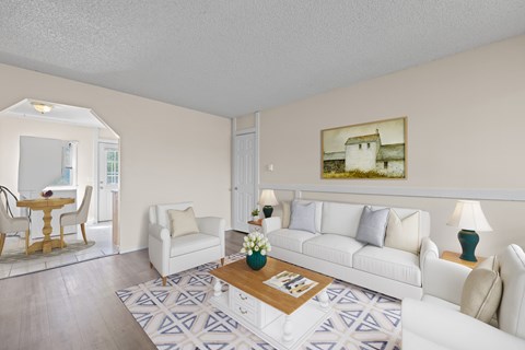 A living room with a white couch, a coffee table, and a painting on the wall.