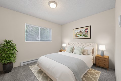 A bedroom with a large bed, a potted plant, and a painting on the wall.