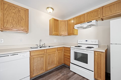 A kitchen with wooden cabinets and white appliances.