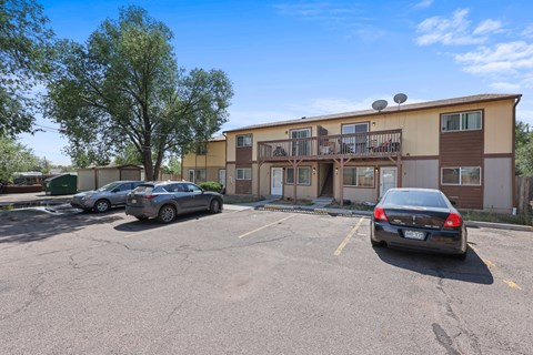 A parking lot with a building and cars.