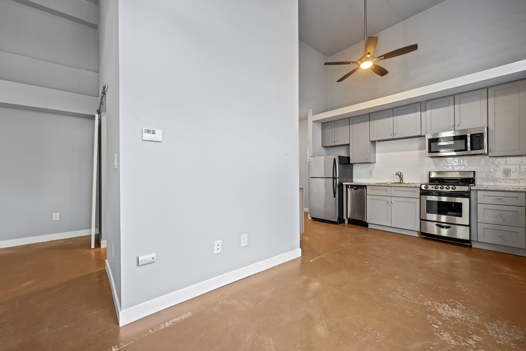 A kitchen with a stove top oven and a fan.