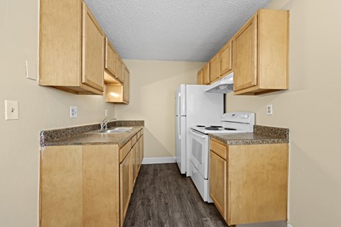A kitchen with wooden cabinets and a white refrigerator.