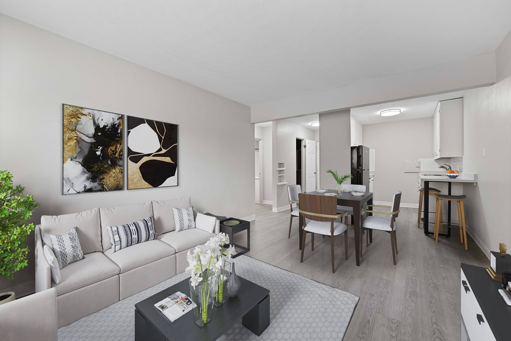 A living room with a grey couch, a coffee table, and a dining table with chairs.