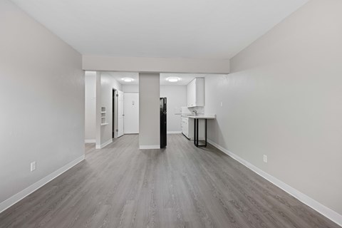 A long, empty hallway with a kitchen area at the end.
