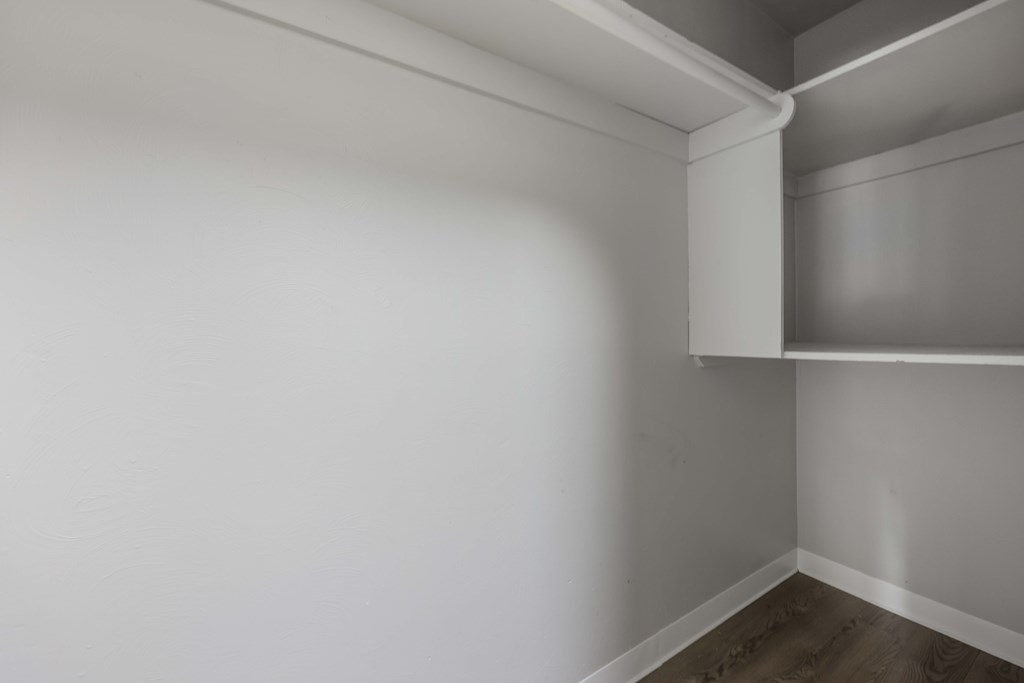 A white wall with a corner shelf.
