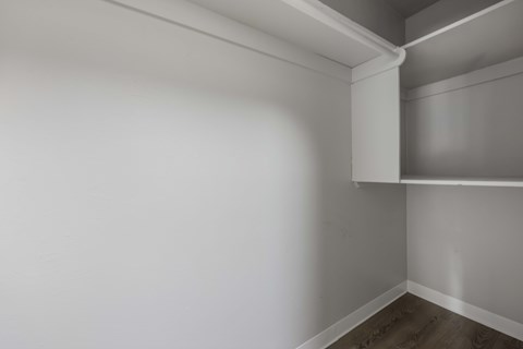 A white wall with a corner shelf.