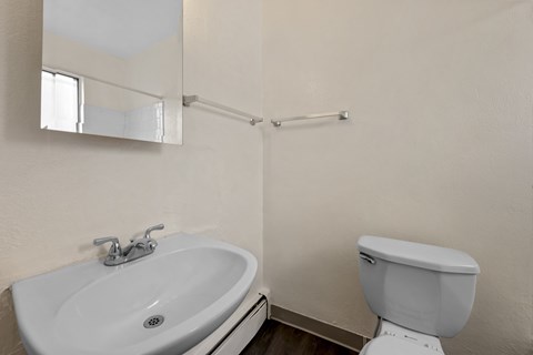A white toilet sits next to a sink in a bathroom.