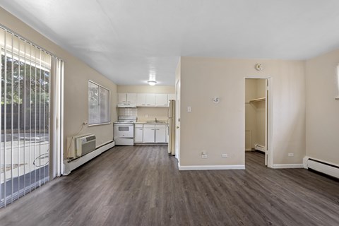 A kitchen with white appliances and a wooden floor.