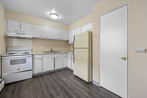 A kitchen with white appliances and cabinets.