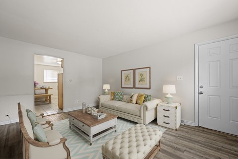 A living room with a white couch and a wooden coffee table.