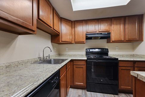 A kitchen with brown cabinets and a black oven.