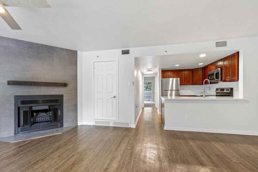 A spacious living room with a fireplace and hardwood floors.
