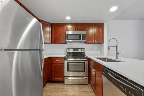 A kitchen with wooden cabinets and stainless steel appliances.