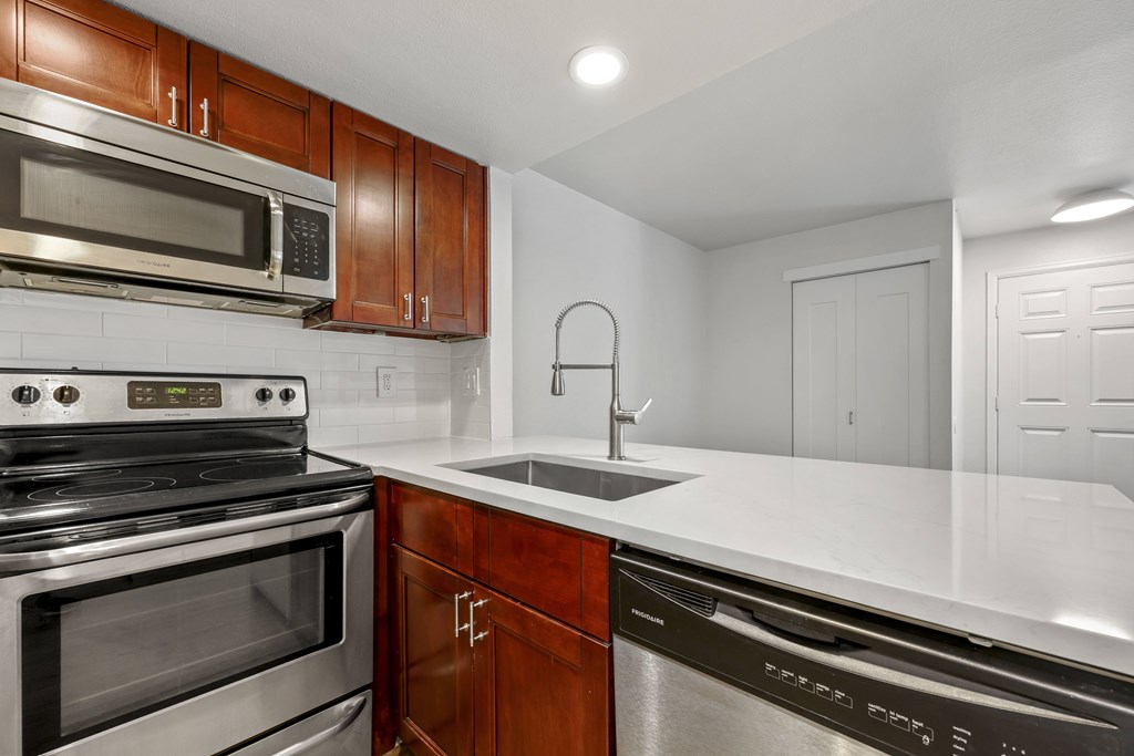 A modern kitchen with a stainless steel dishwasher and a black oven.