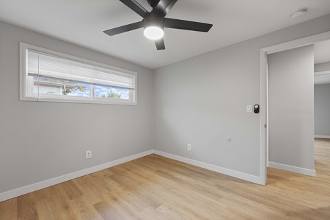 A room with a ceiling fan and a window.