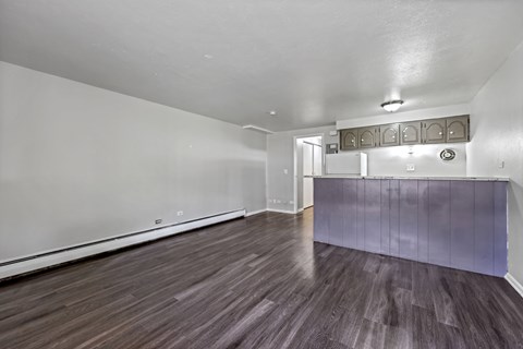 A room with wooden flooring and white walls.