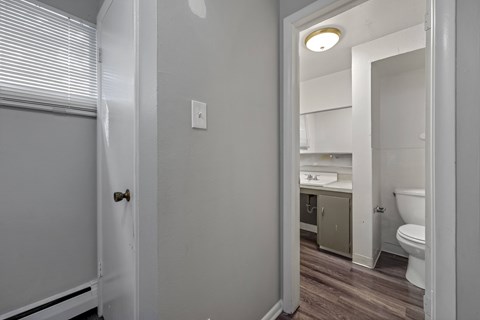 A bathroom with a toilet, sink, and cabinet.