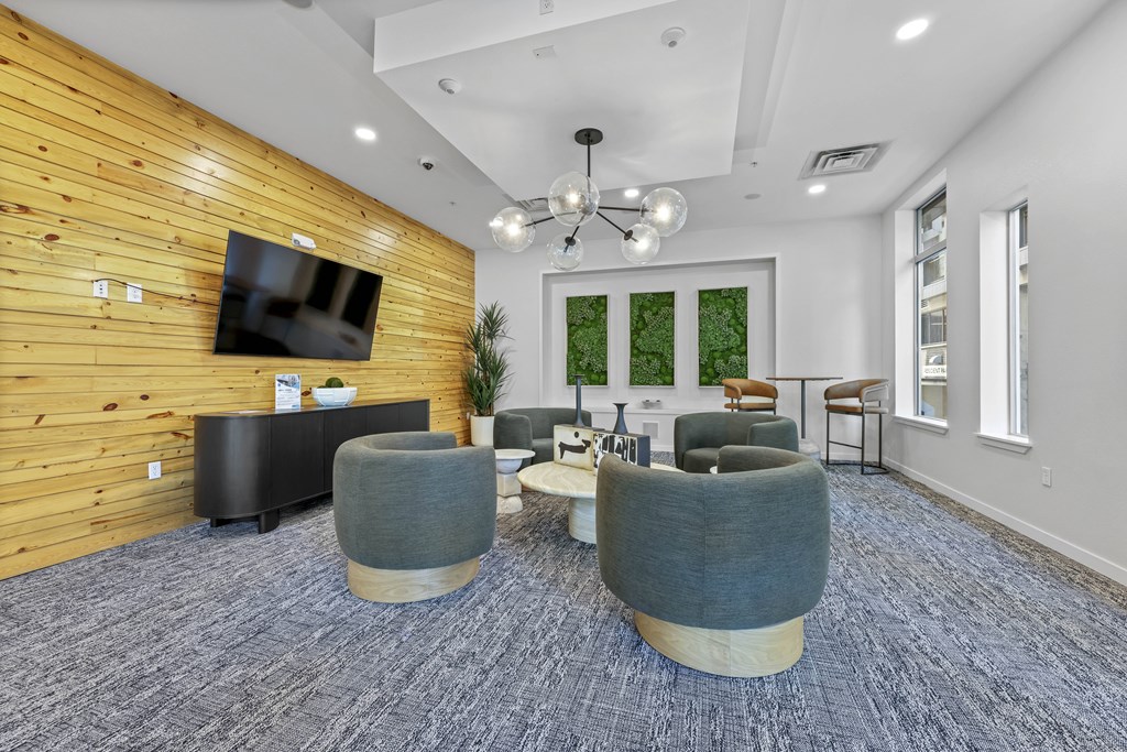 A room with a wooden wall and grey chairs.