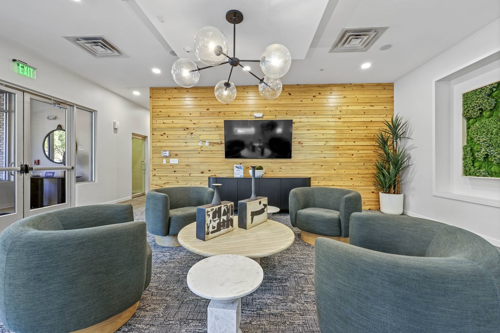 A modern waiting room with grey chairs and a wooden wall.