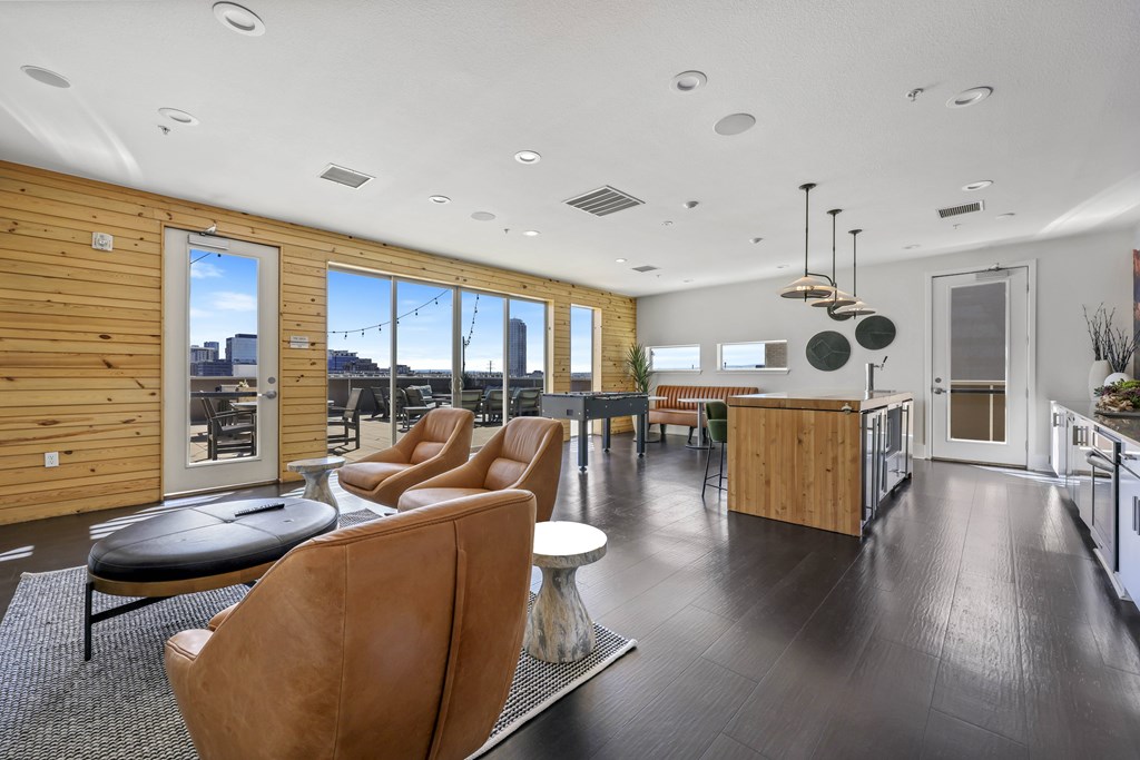 A modern living room with brown leather chairs and a wooden wall.