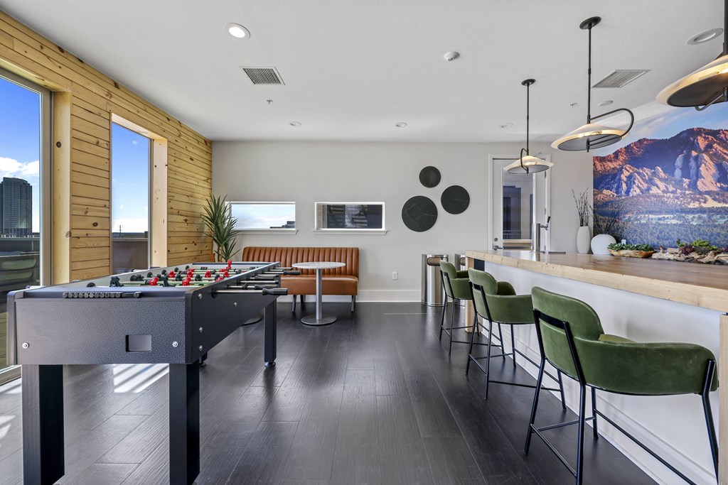 A room with a pool table and a bar area.