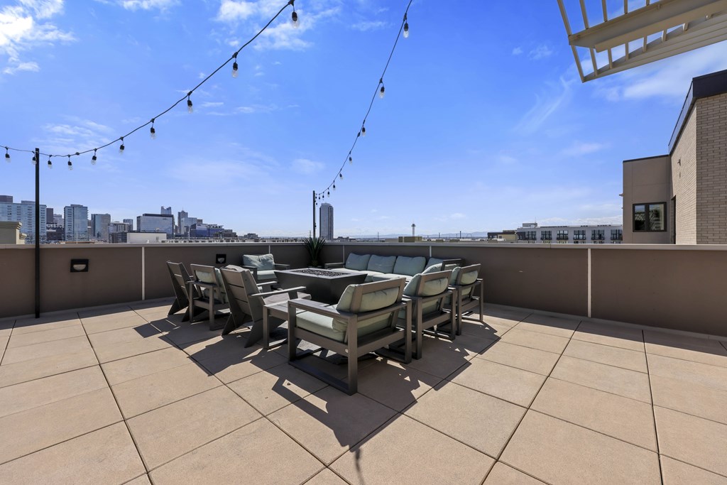 A patio with a table and chairs overlooking a city skyline.