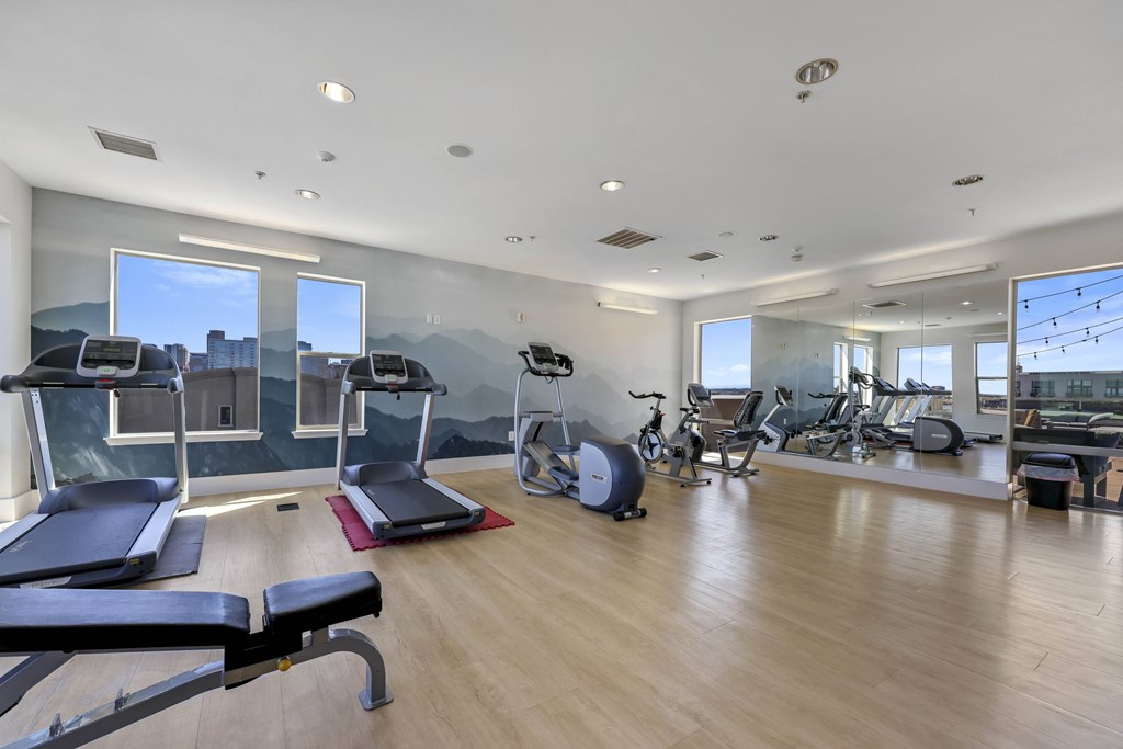 A spacious gym with a variety of equipment including treadmills, exercise bikes, and weight machines.