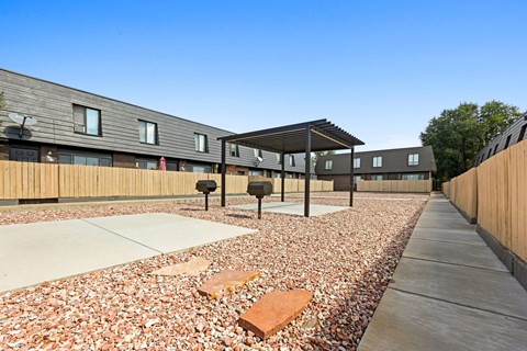 A building with a wooden fence and a gravel area in front.