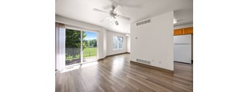 A room with a ceiling fan and wooden flooring.