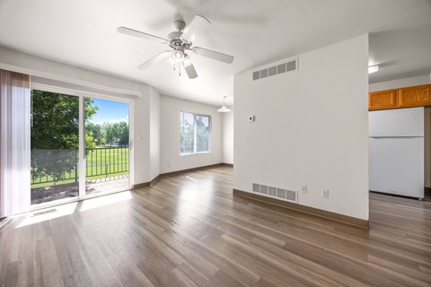 A room with a ceiling fan and wooden flooring.