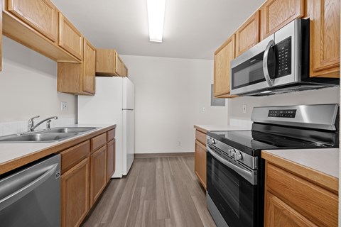 A kitchen with wooden cabinets and stainless steel appliances.