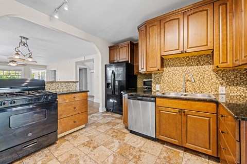 A kitchen with wooden cabinets and a black refrigerator.