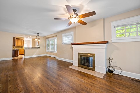 A living room with a fireplace and wood floors.
